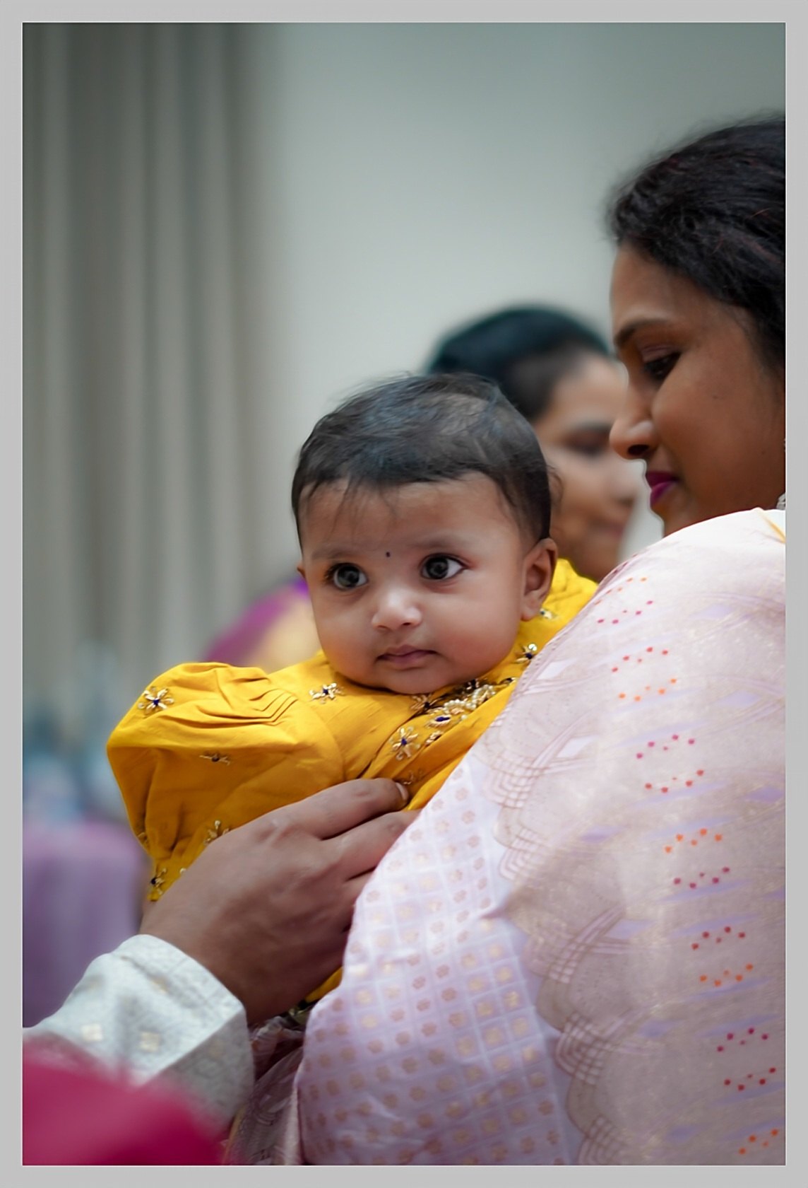 A baby held close at a family celebration